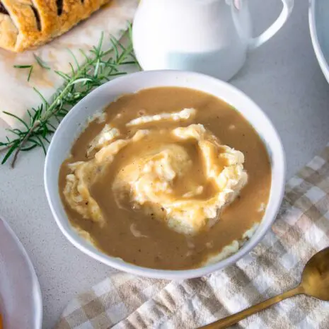 Holiday vegan mashed potatoes and mushroom gravy served in a white bowl