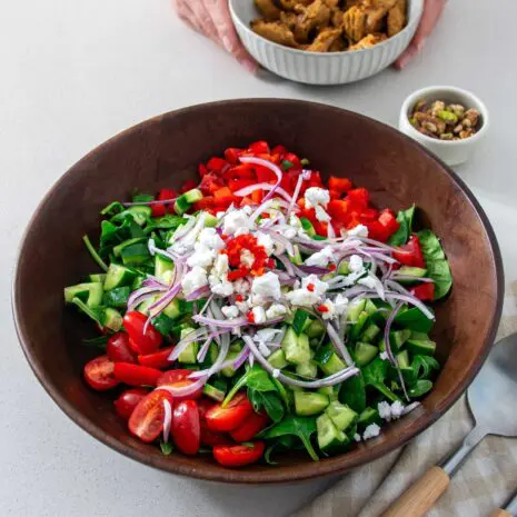 Big wooden salad bowl full of vibrant tomatoes, cucumber and veggies based on Florence Pugh's Salad