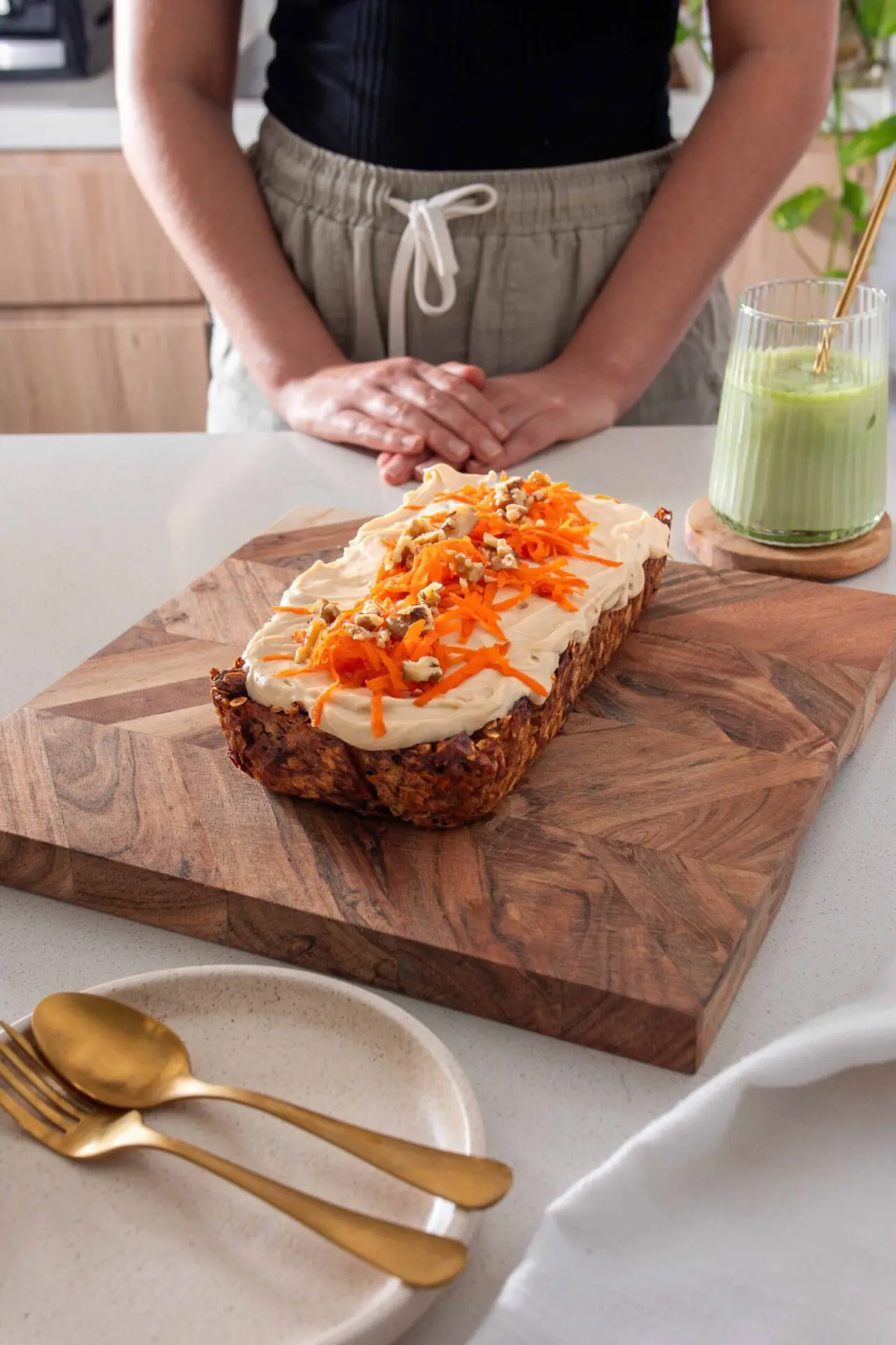 Baked Oats Carrot Cake on a wooden serving board alongside plate with spoon and fork