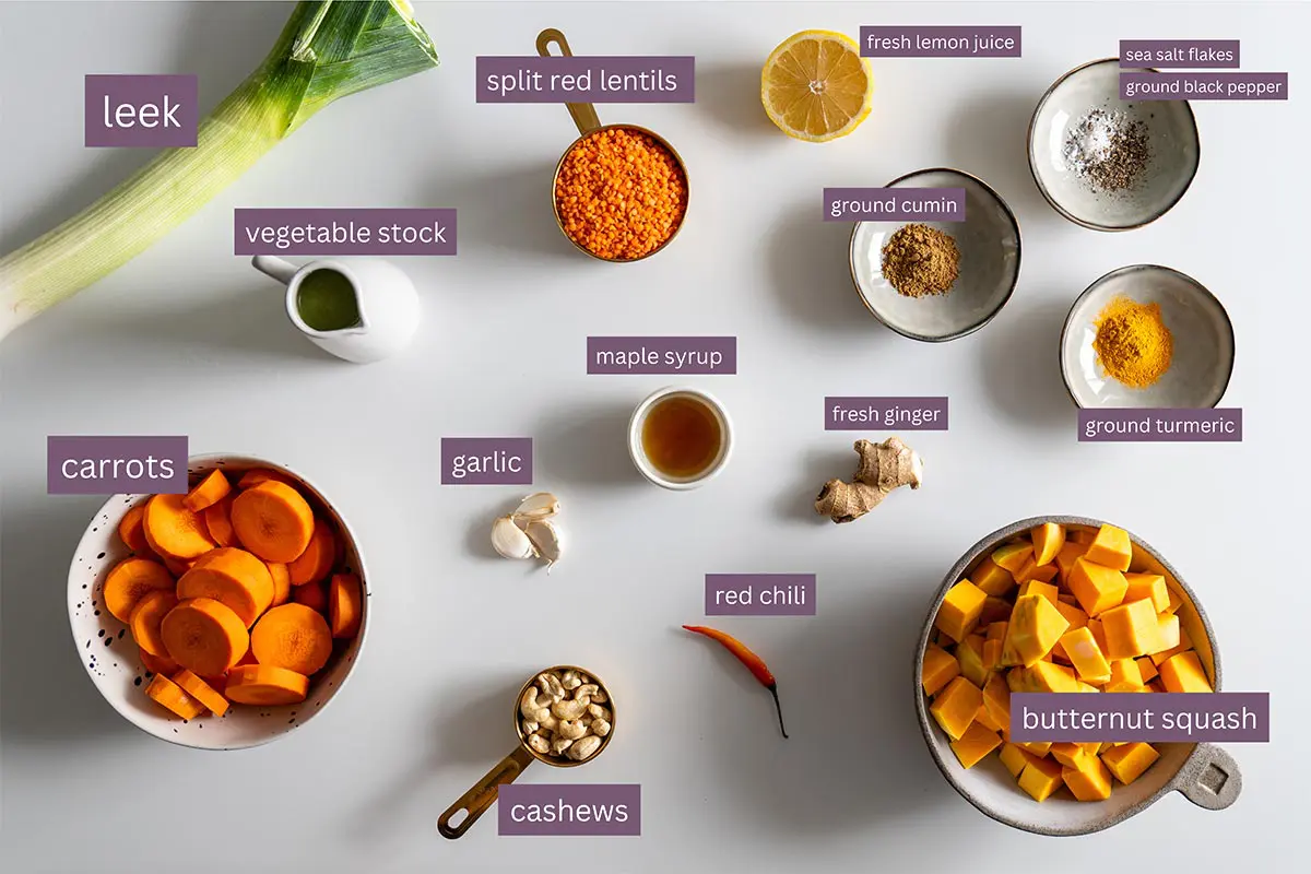 Ingredients for nutritious butternut squash and red lentil soup displayed on a white surface.