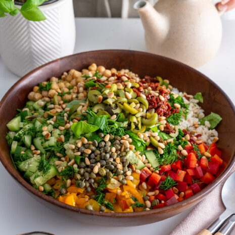 Colorful Mediterranean chopped salad in a wooden bowl, ready to be tossed.