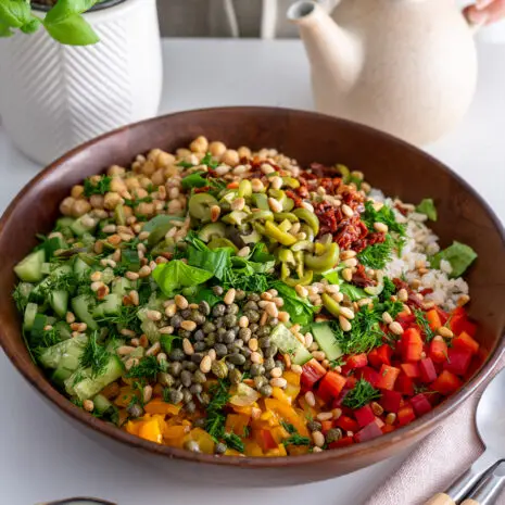 Colorful Mediterranean chopped salad in a wooden bowl, ready to be tossed.