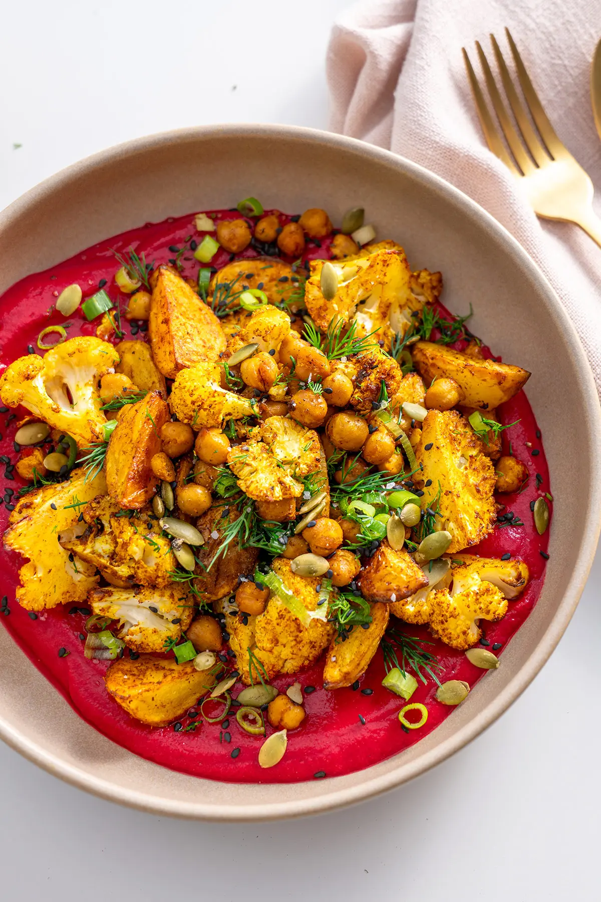 Overhead view of a high-protein beetroot bowl, ready to eat, with fresh herbs on top.