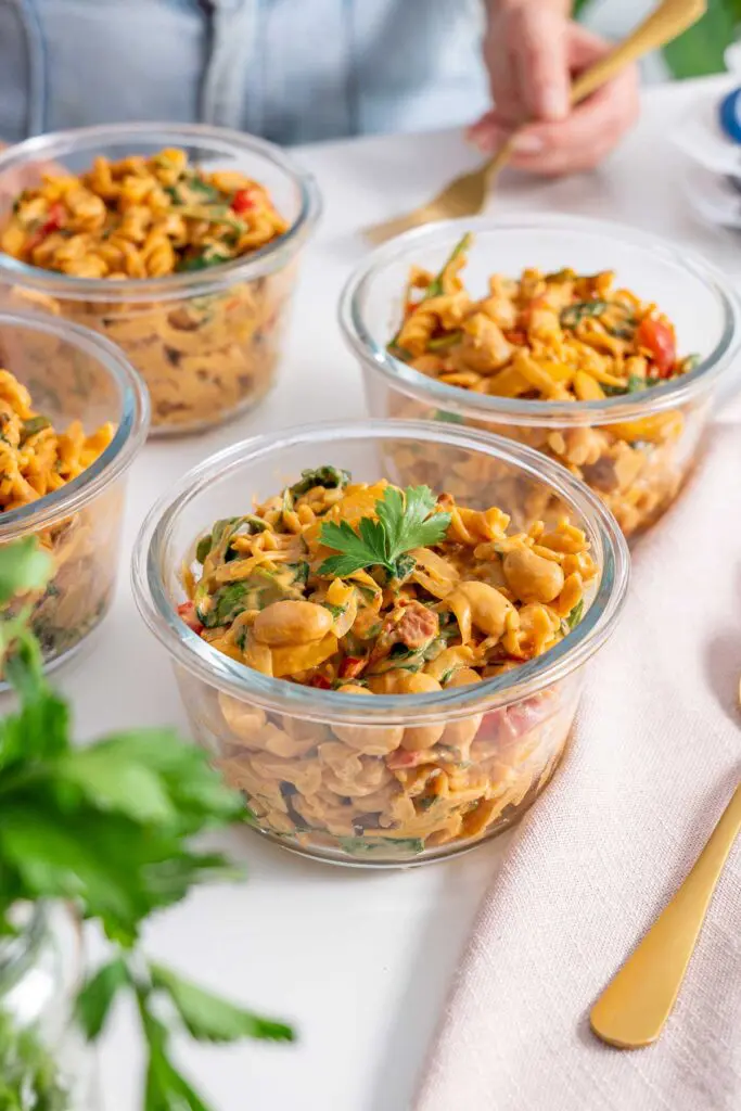 Glass bowls of 'High-Protein Vegan Marry Me Pasta' meal prepped and garnished with parsley.