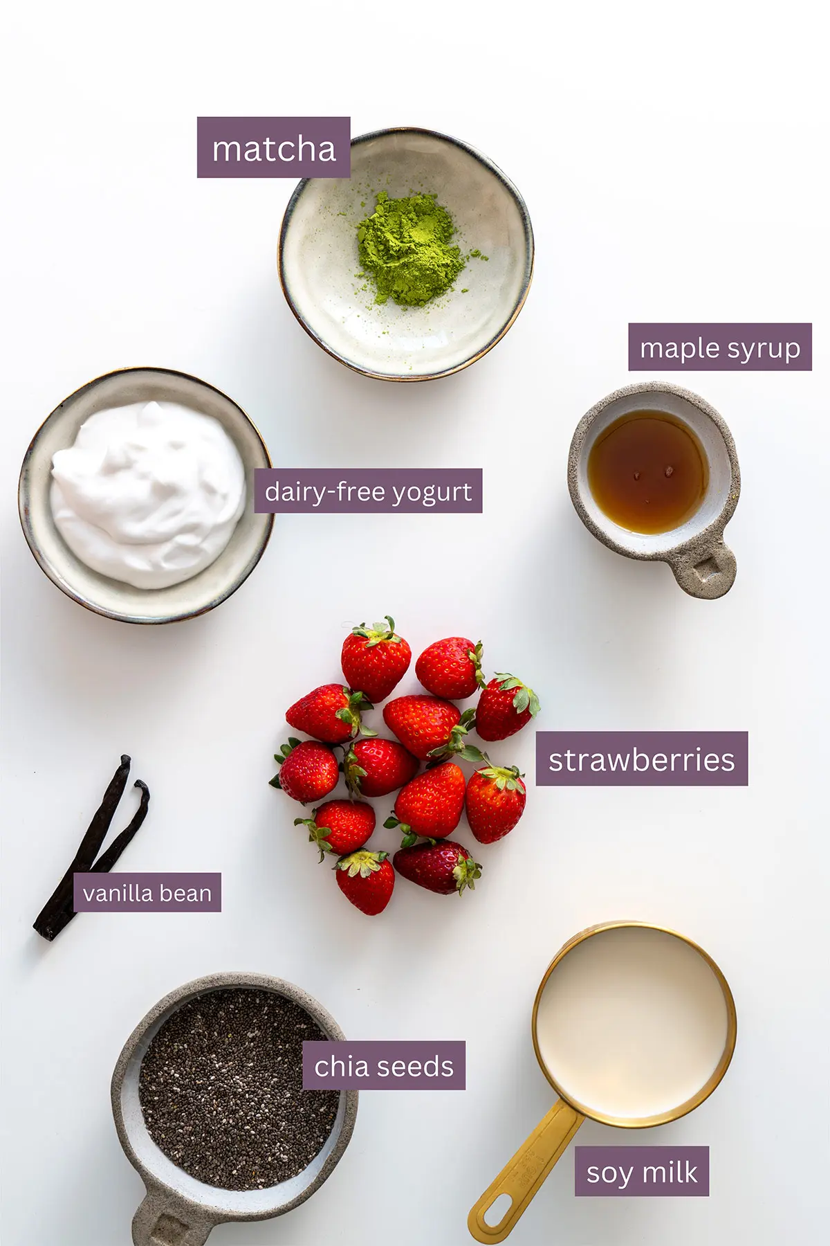 Assorted ingredients for strawberry matcha chia pudding laid out on a white background.