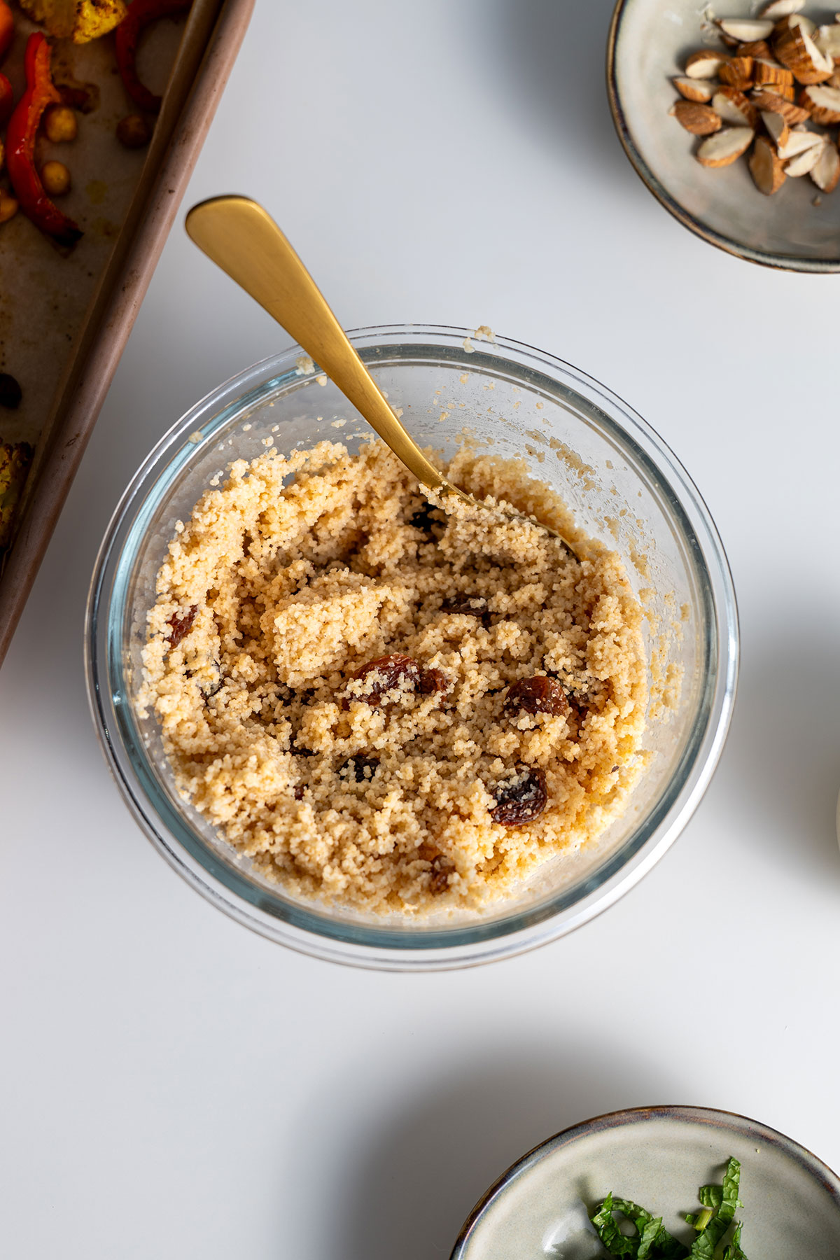 Couscous mixed with raisins in a glass bowl.