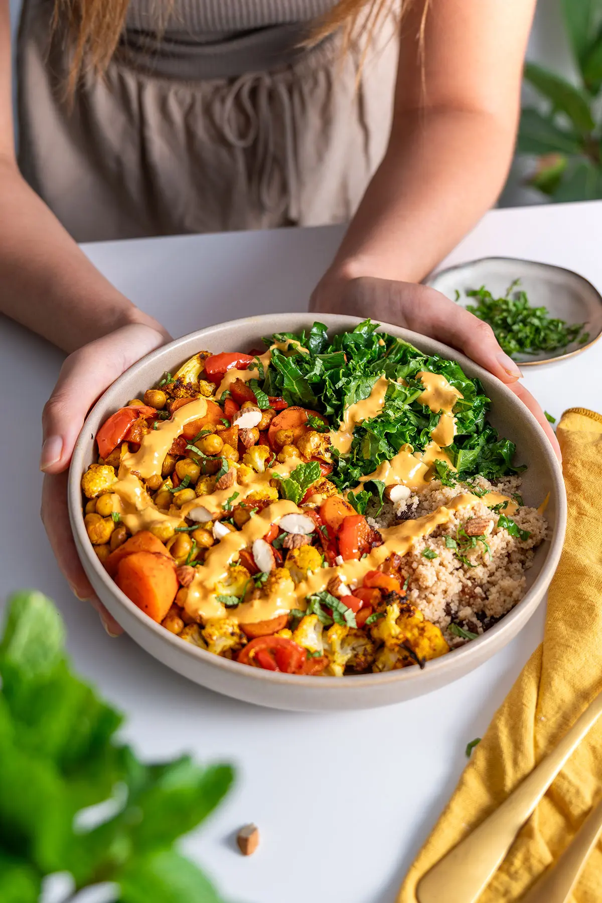 Sarah Cobacho serving a Moroccan-inspired nourish bowl filled with colorful vegetables and grains.
