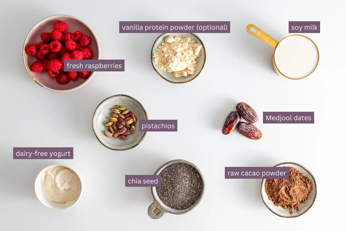 Vibrant ingredients for a cacao chia pudding recipe on a white surface.