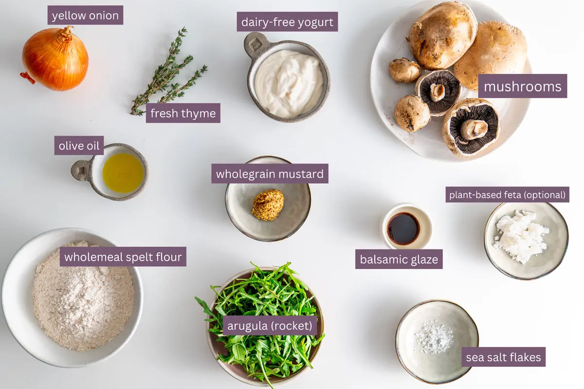 Ingredients for a Caramelized Onion Mushroom Galette recipe displayed on a white surface.