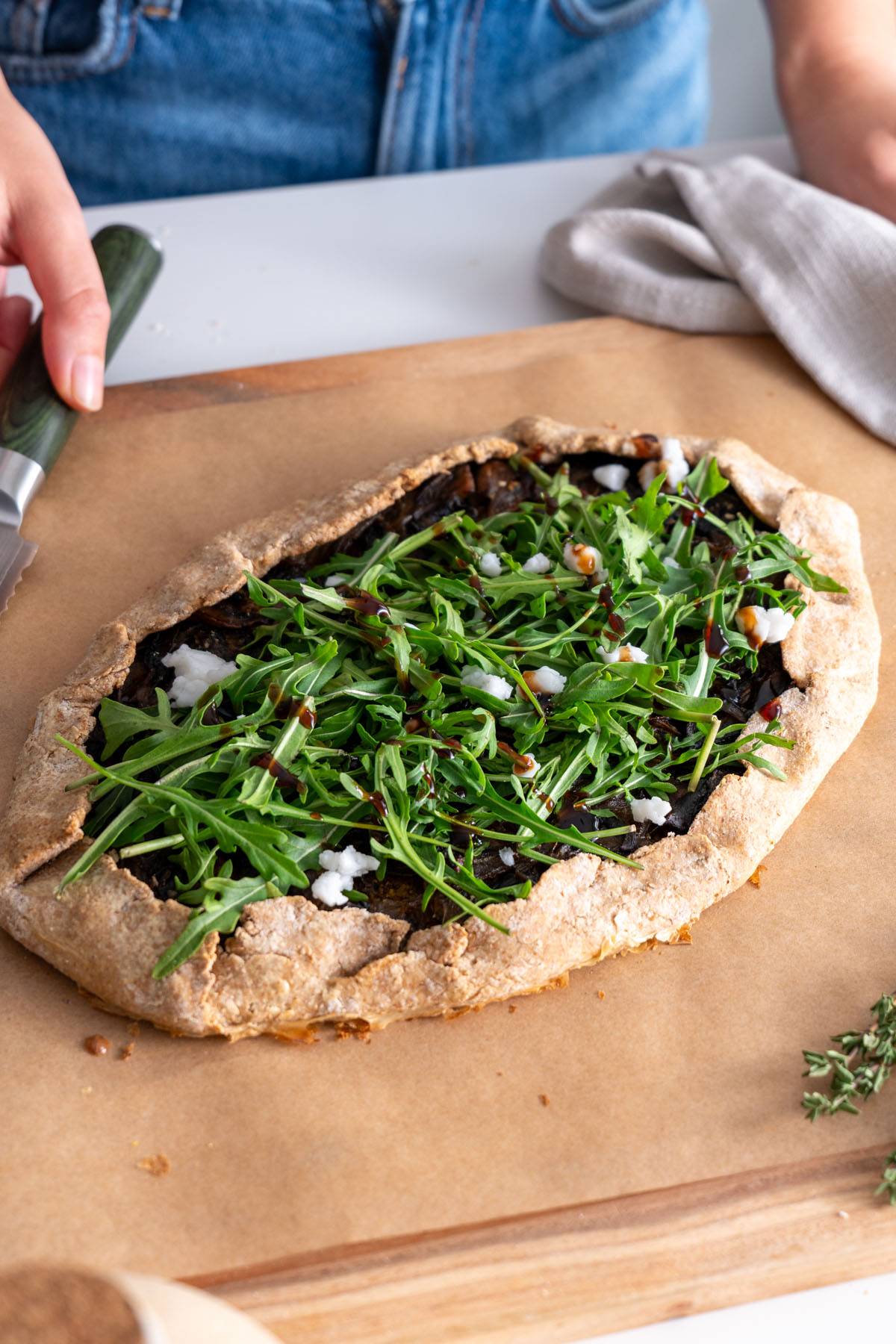 Bánh Galette phủ rau arugula tươi, phô mai feta thực vật và nước sốt balsamic.