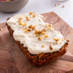 Loaf of apple pie baked oats topped with protein icing and chopped walnuts.
