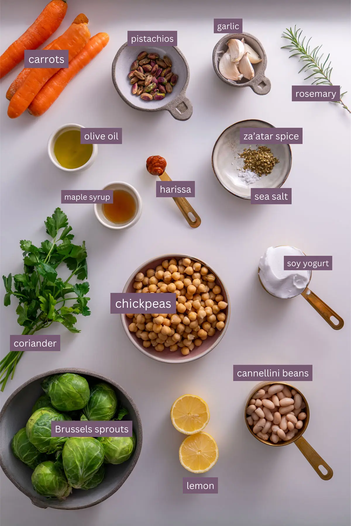 Vibrant ingredients for Sweet & Spicy Roasted Veggies on a White Bean Spread on a white surface.