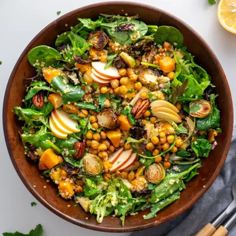 Close-up of a colorful fall salad with Brussels sprouts, roasted chickpeas, and fresh greens.