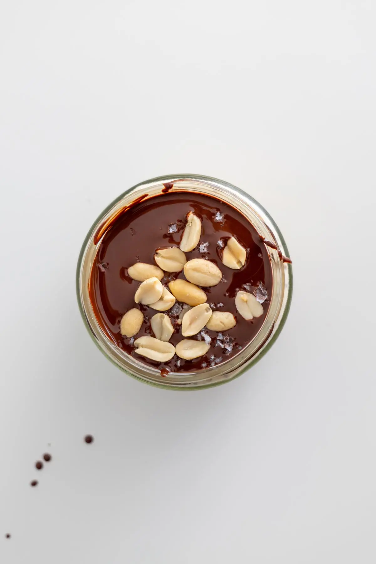 Overhead view of Snickers overnight oats topped with chocolate and chopped peanuts.