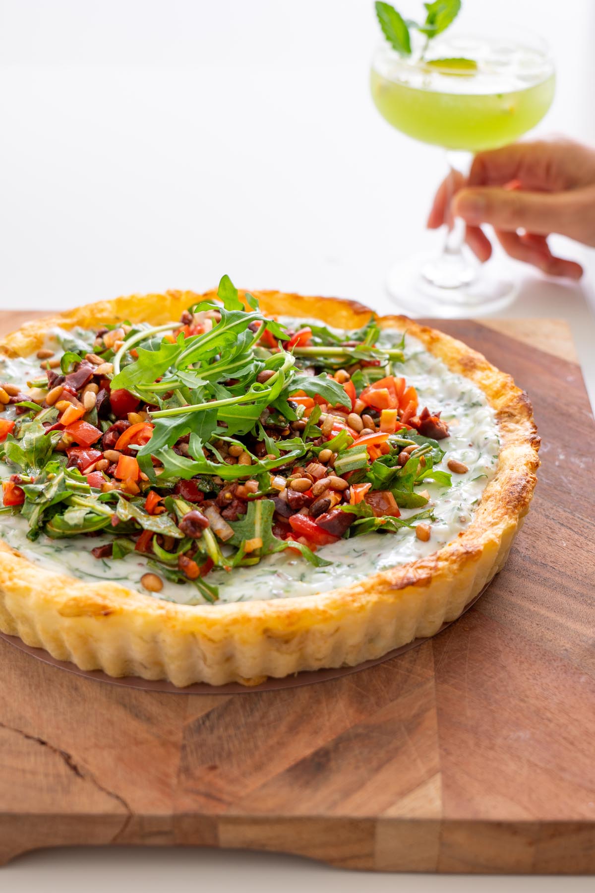 Sarah Cobacho holding drink with a slice of Mediterranean potato tart