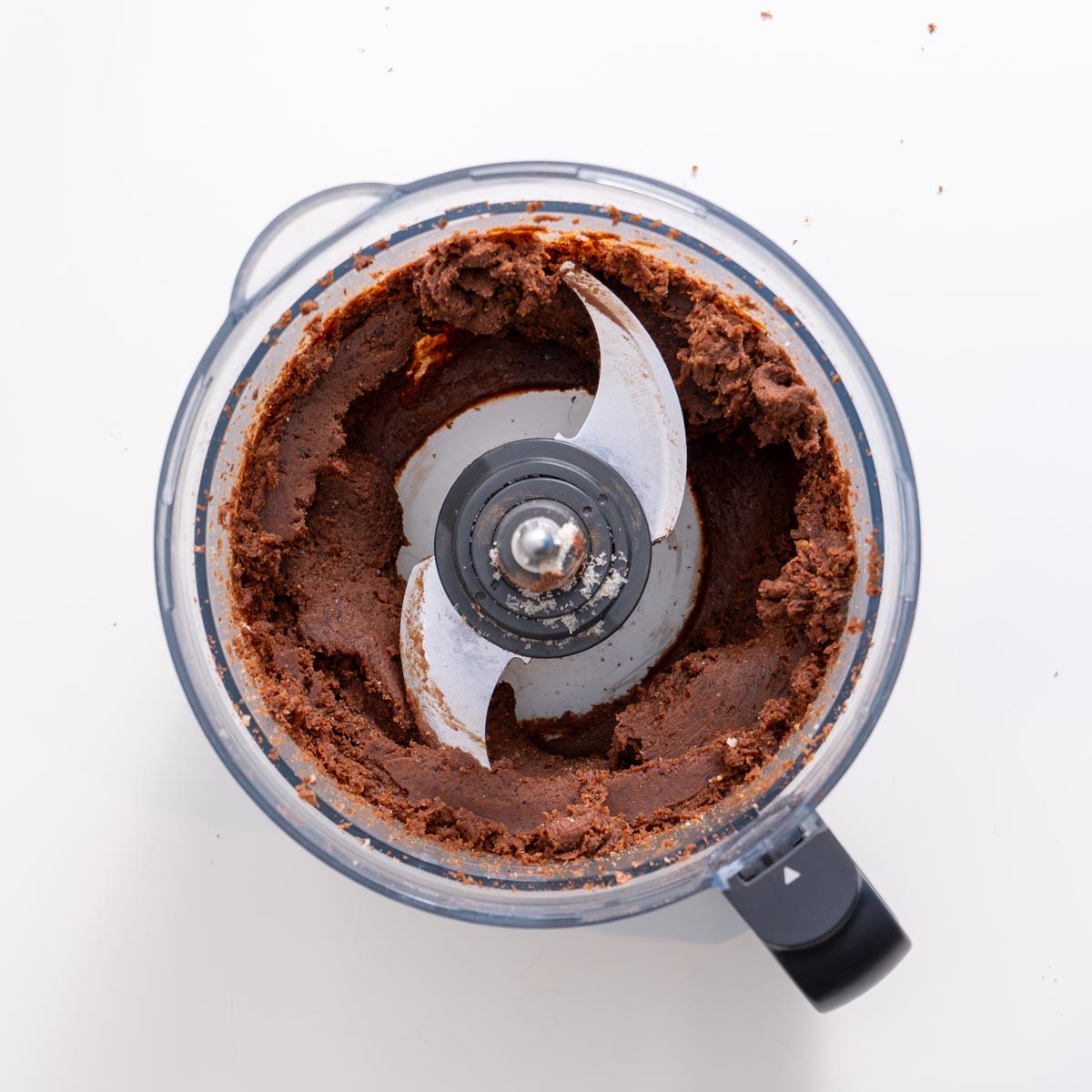 Food processor filled with blended fudgy no-bake brownie dough