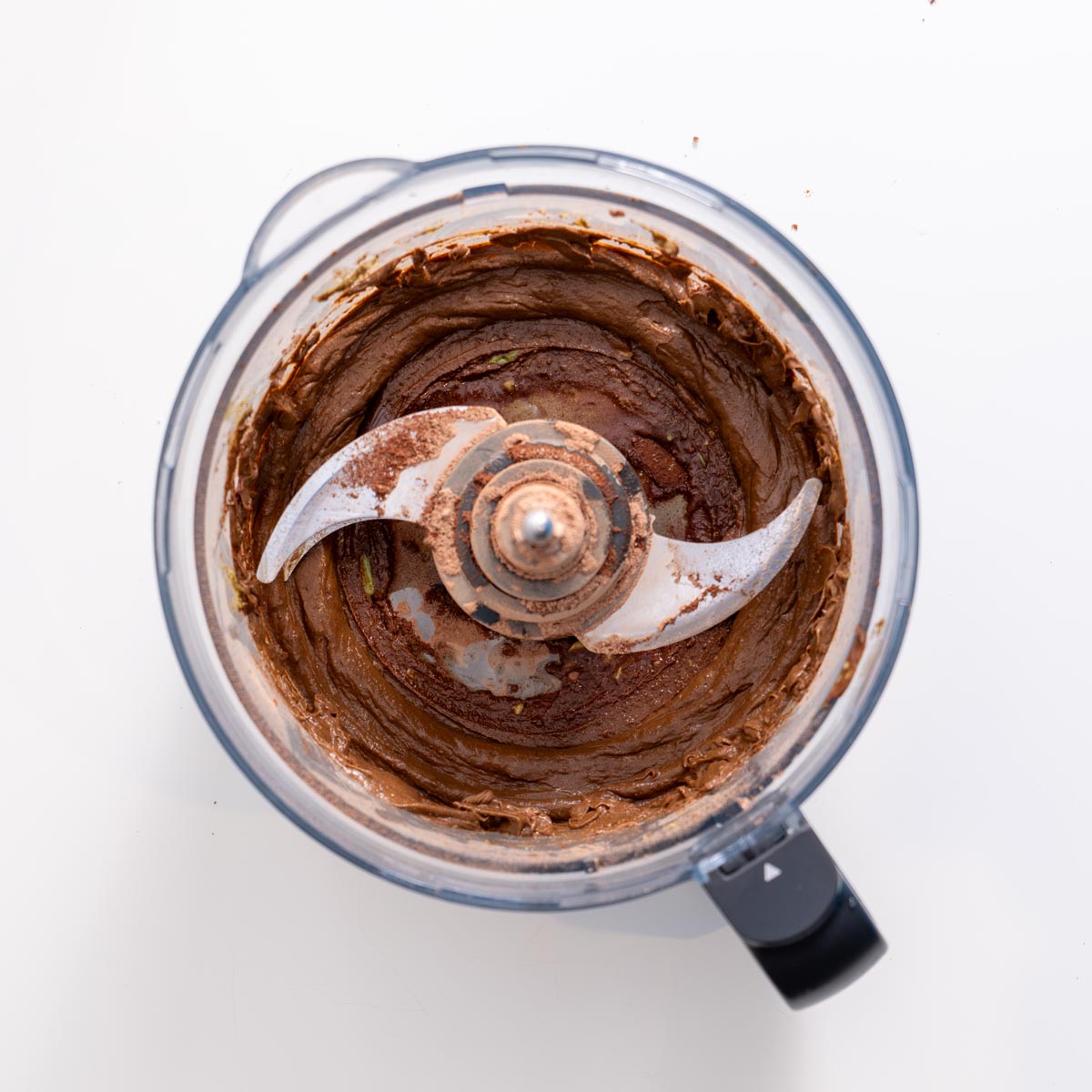 Food processor filled with smooth avocado ganache mixture for brownies