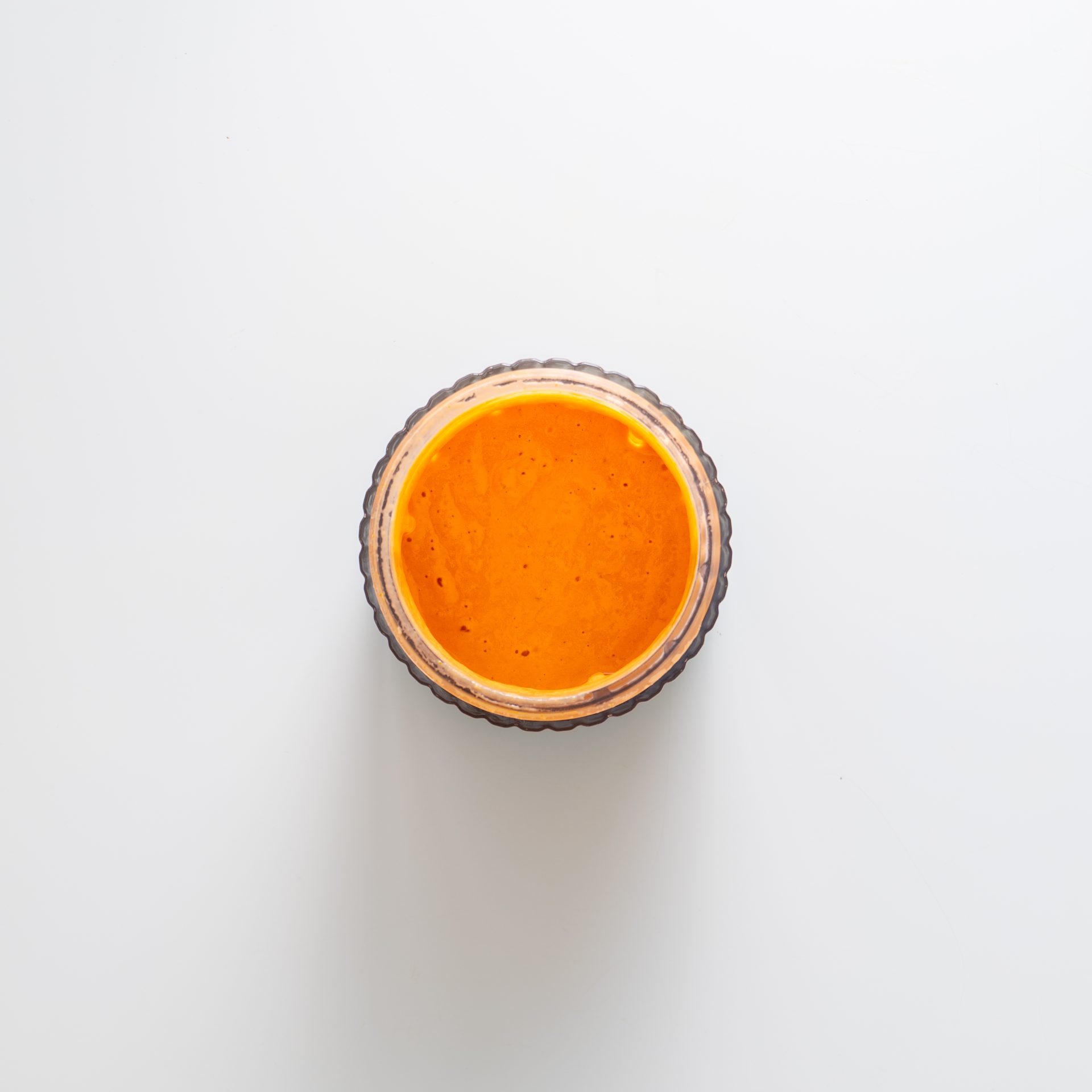 Creamy tahini sun-dried tomato sauce in a glass bowl on a white background