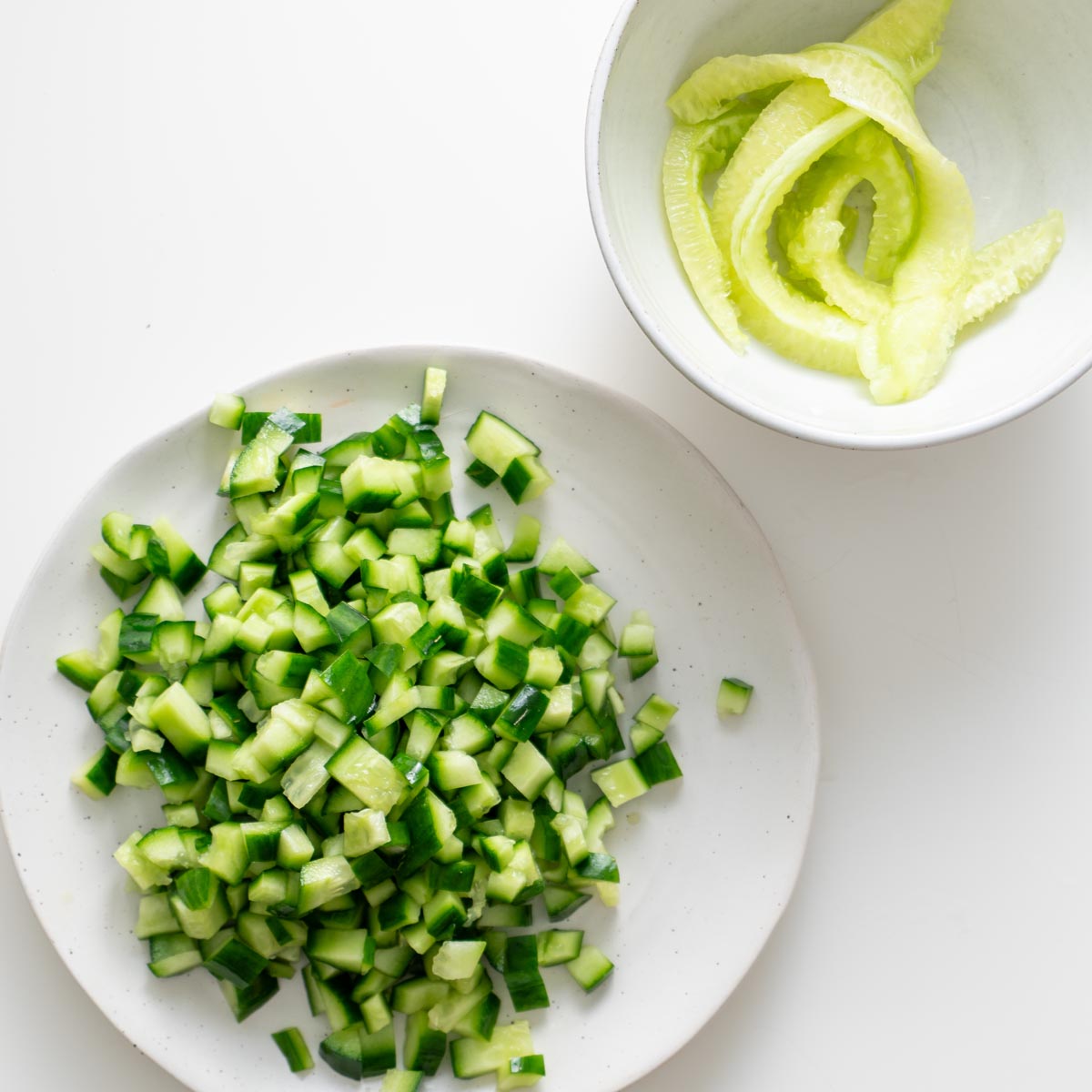 Diced cucumber with scooped cores set aside for peanut vermicelli salad jars