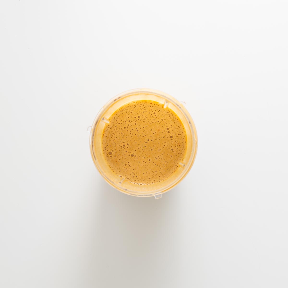 Creamy blended peanut ginger lime dressing in a small blender cup