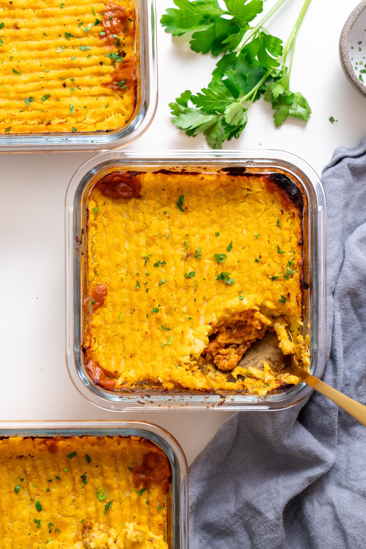 overhead baked cottage pie in a glass dish topped with parsley