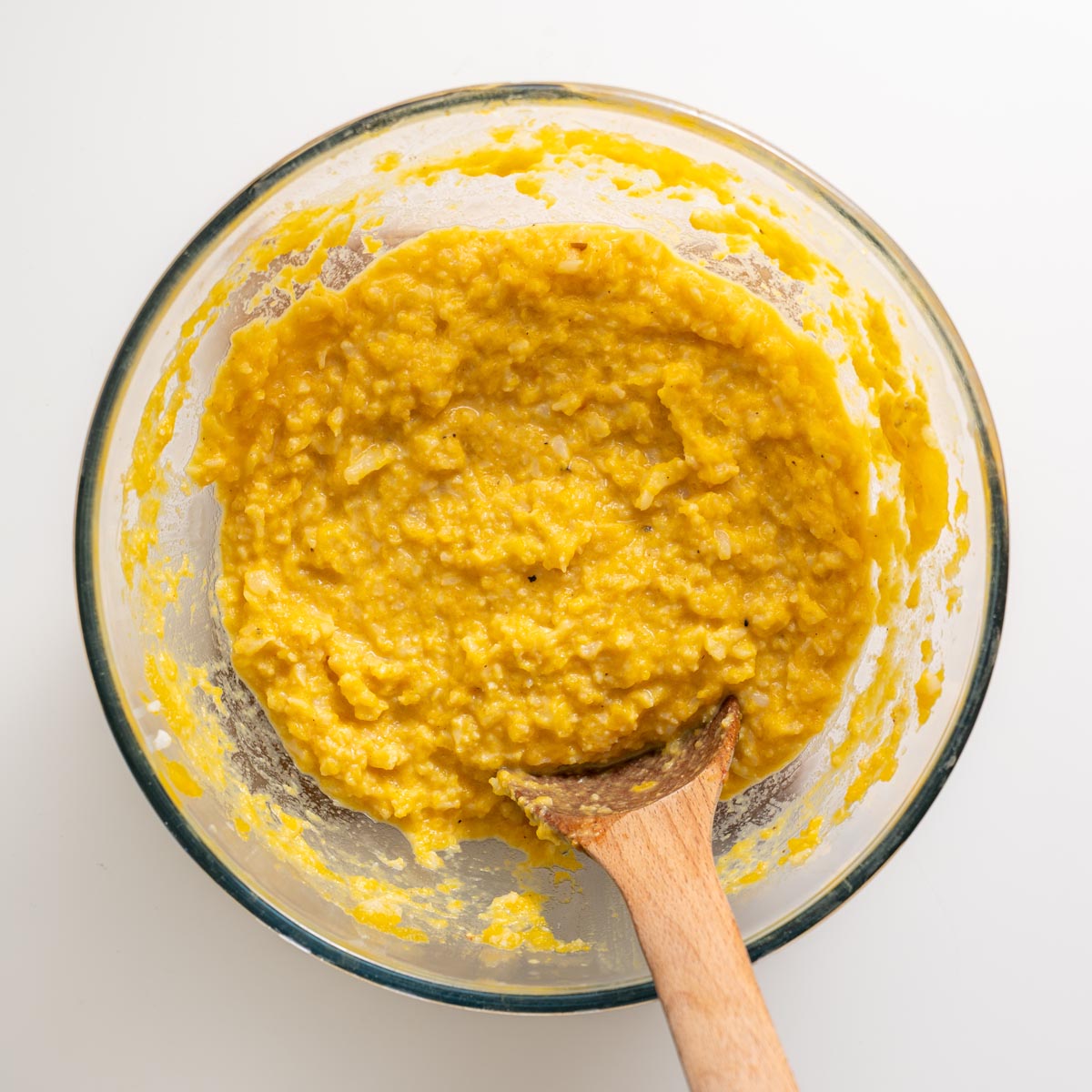 bowl of mashed butternut squash and cauliflower mash with wooden spoon