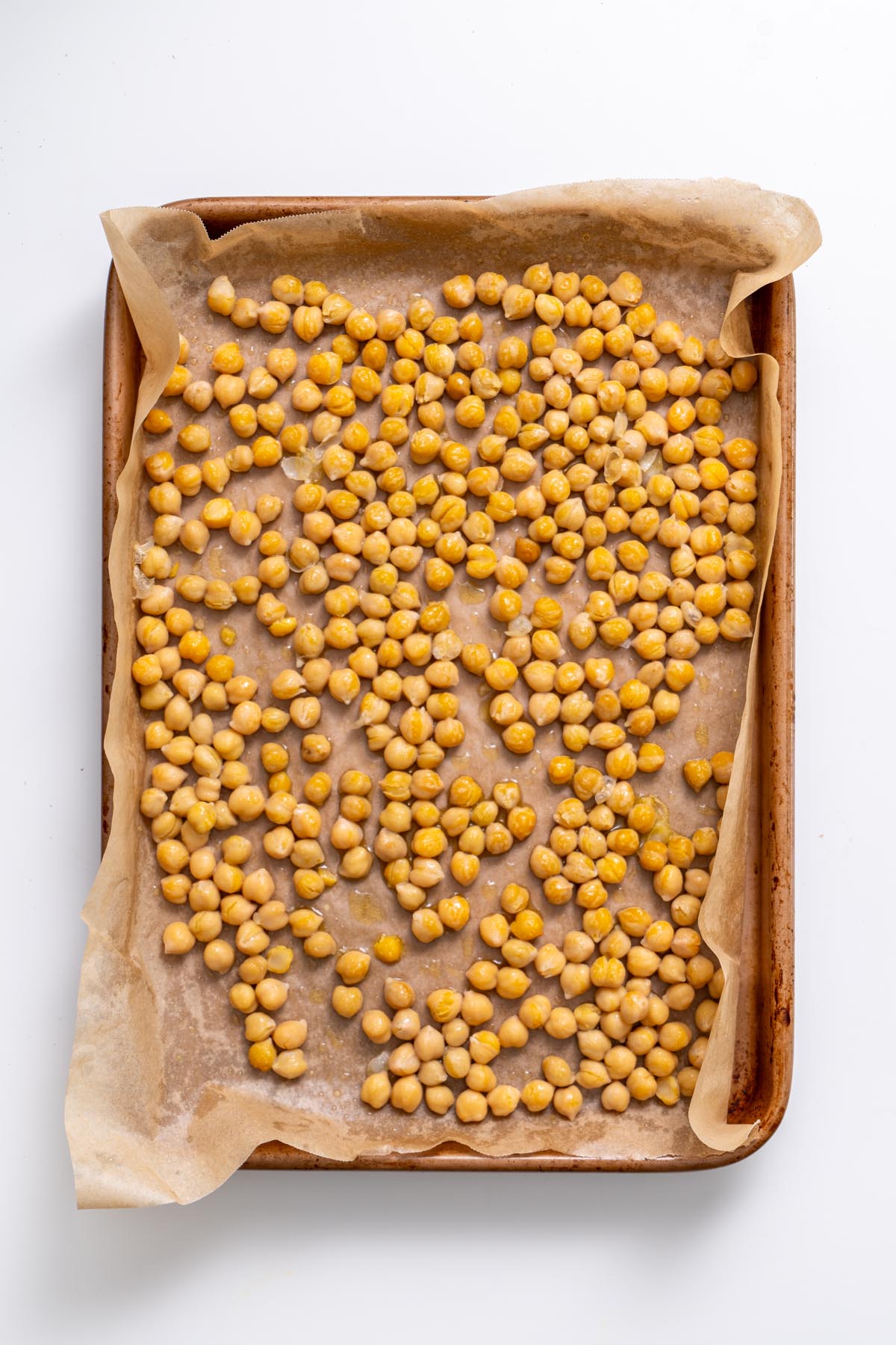 Chickpeas for festive maple salad on a baking tray ready for roasting