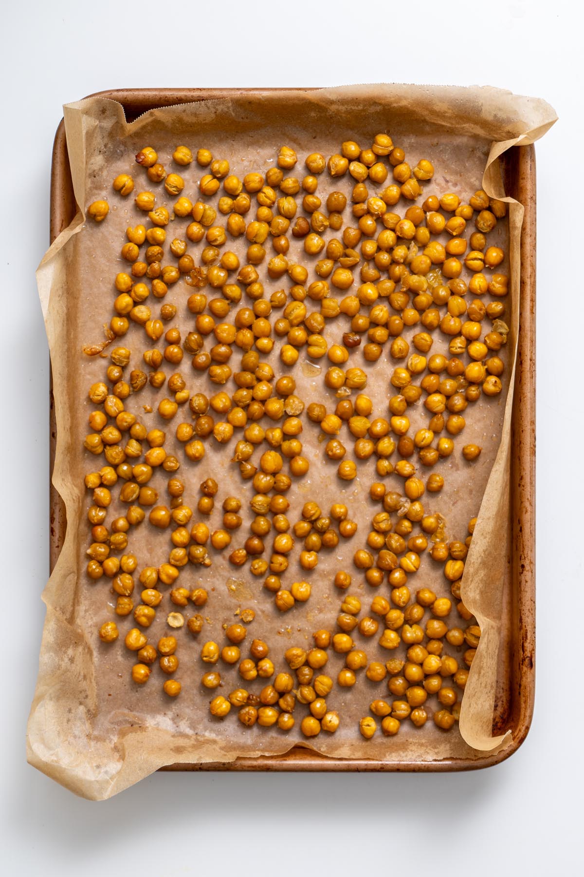 Roasted chickpeas spread on a baking sheet lined with parchment paper