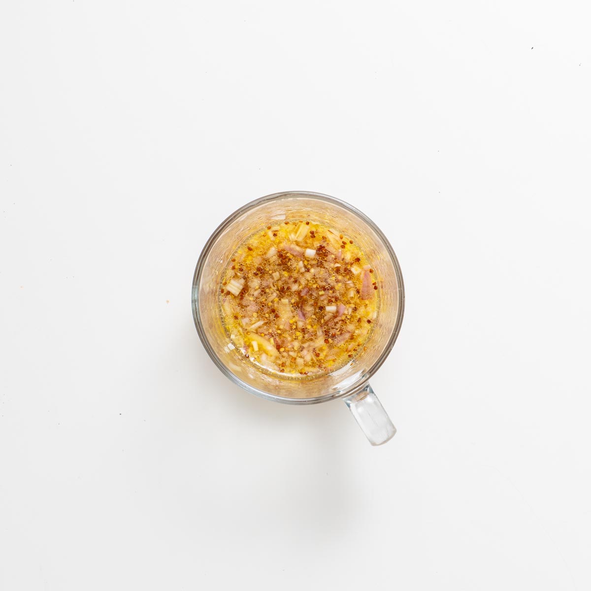 Hỗn hợp dấm phong với hẹ thái hạt lựu trong cốc thủy tinh trên nền trắng