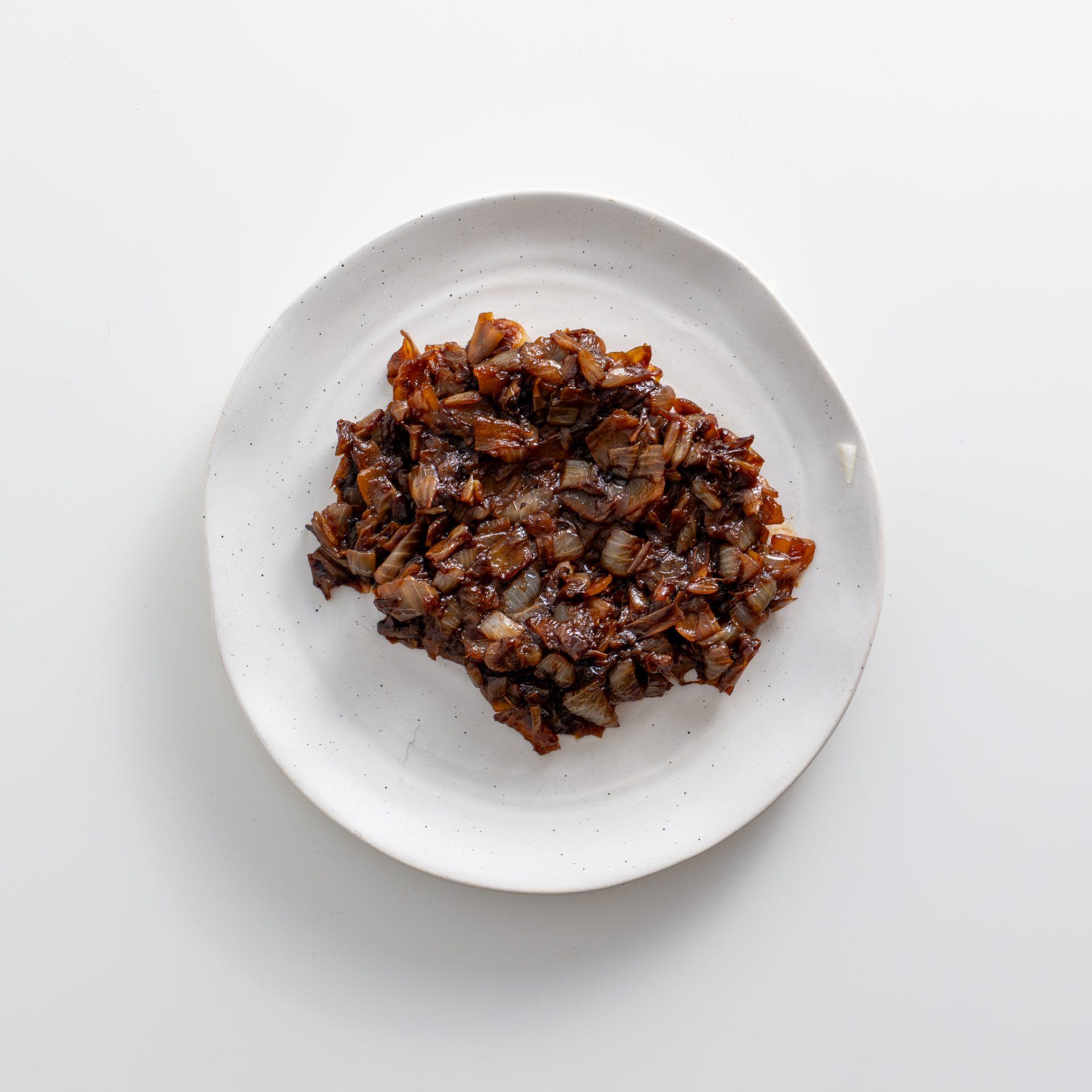Caramelized onions on a white plate showing golden brown jammy texture for French onion dip