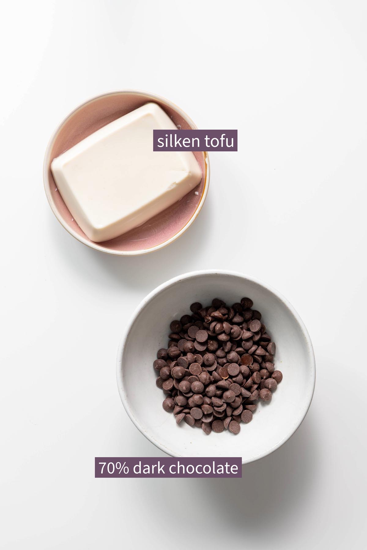 Silken tofu and dark chocolate chips in bowls on a white surface