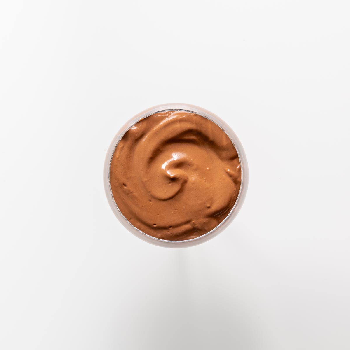 Freshly blended chocolate mousse with a smooth swirl in a glass