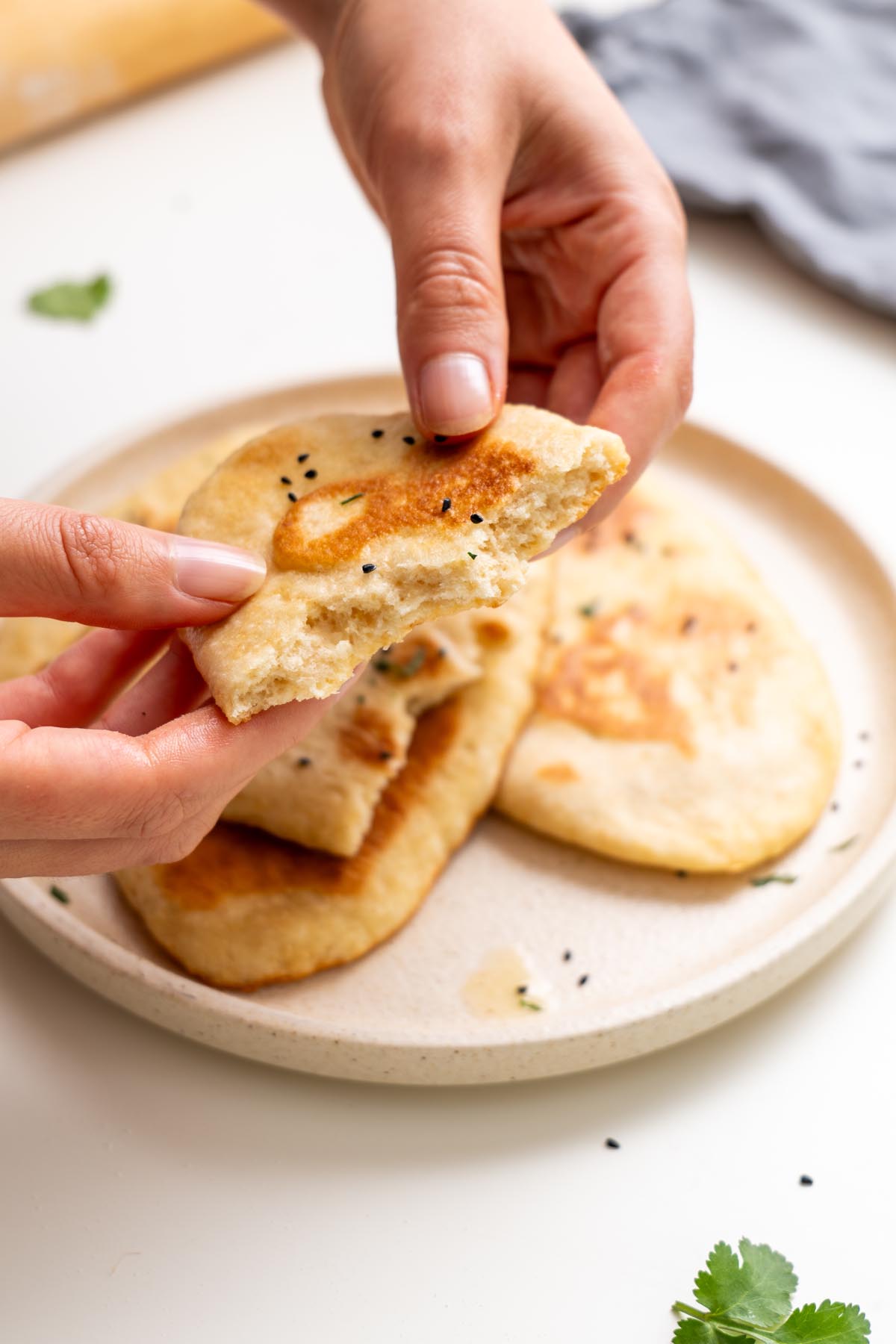 Sarah Cobacho holding a piece of dairy-free naan bread over a plate