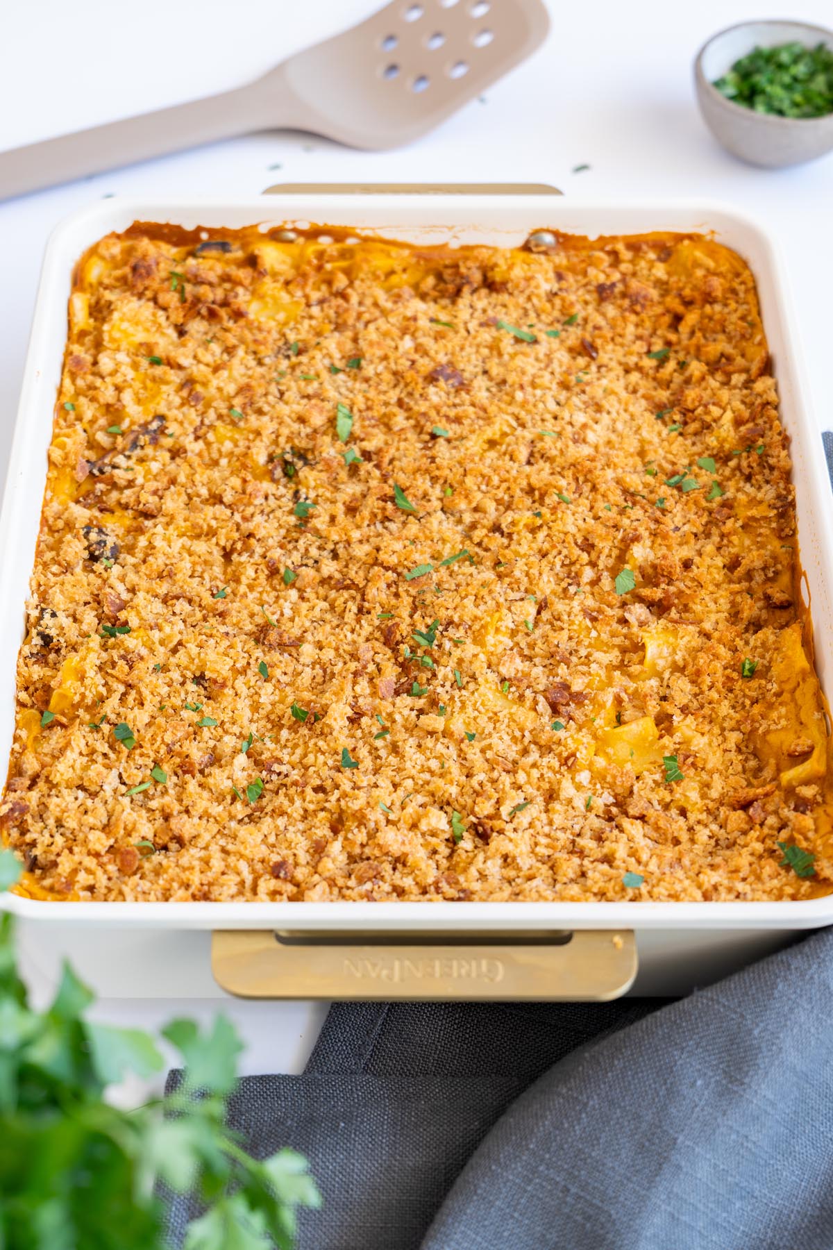 Crispy topped vegan mac and cheese in a baking dish on a white background