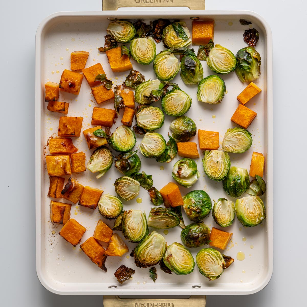 Roasted pumpkin and Brussels sprouts on a baking tray with golden caramelized edges