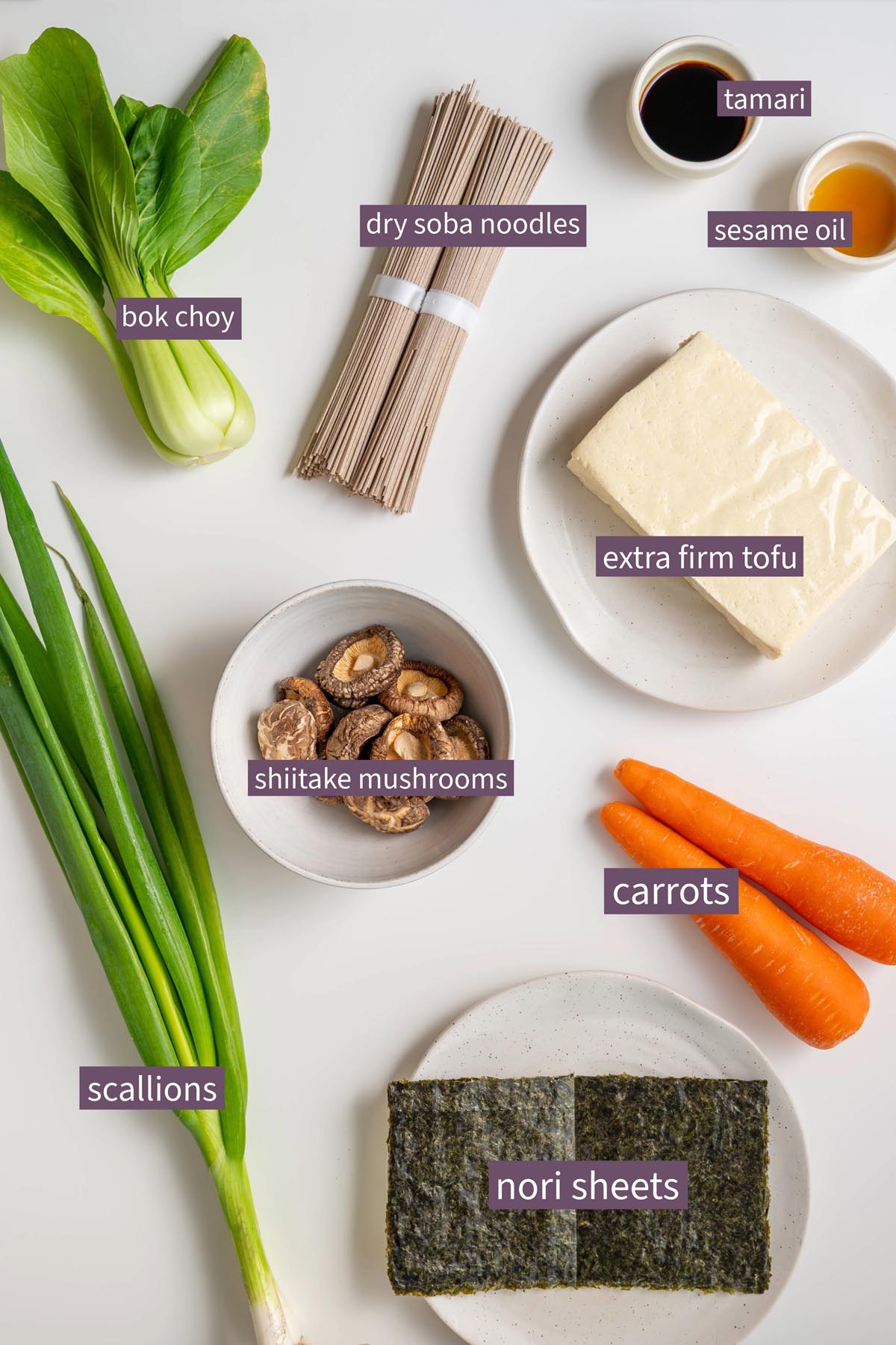 Labeled ingredients for miso noodle soup meal prep on a white surface.