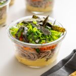 Miso noodle soup meal prep containers with nori and scallions on top.