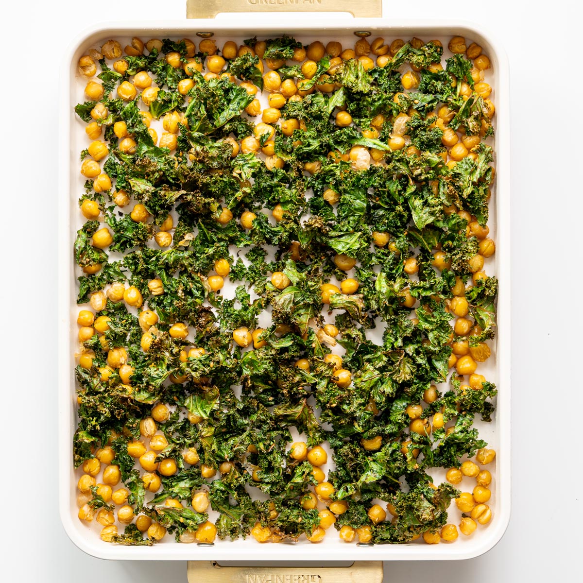 Baking tray with crispy roasted kale and chickpeas seasoned with za'atar spices, ready to top roasted cauliflower and red bell pepper soup.