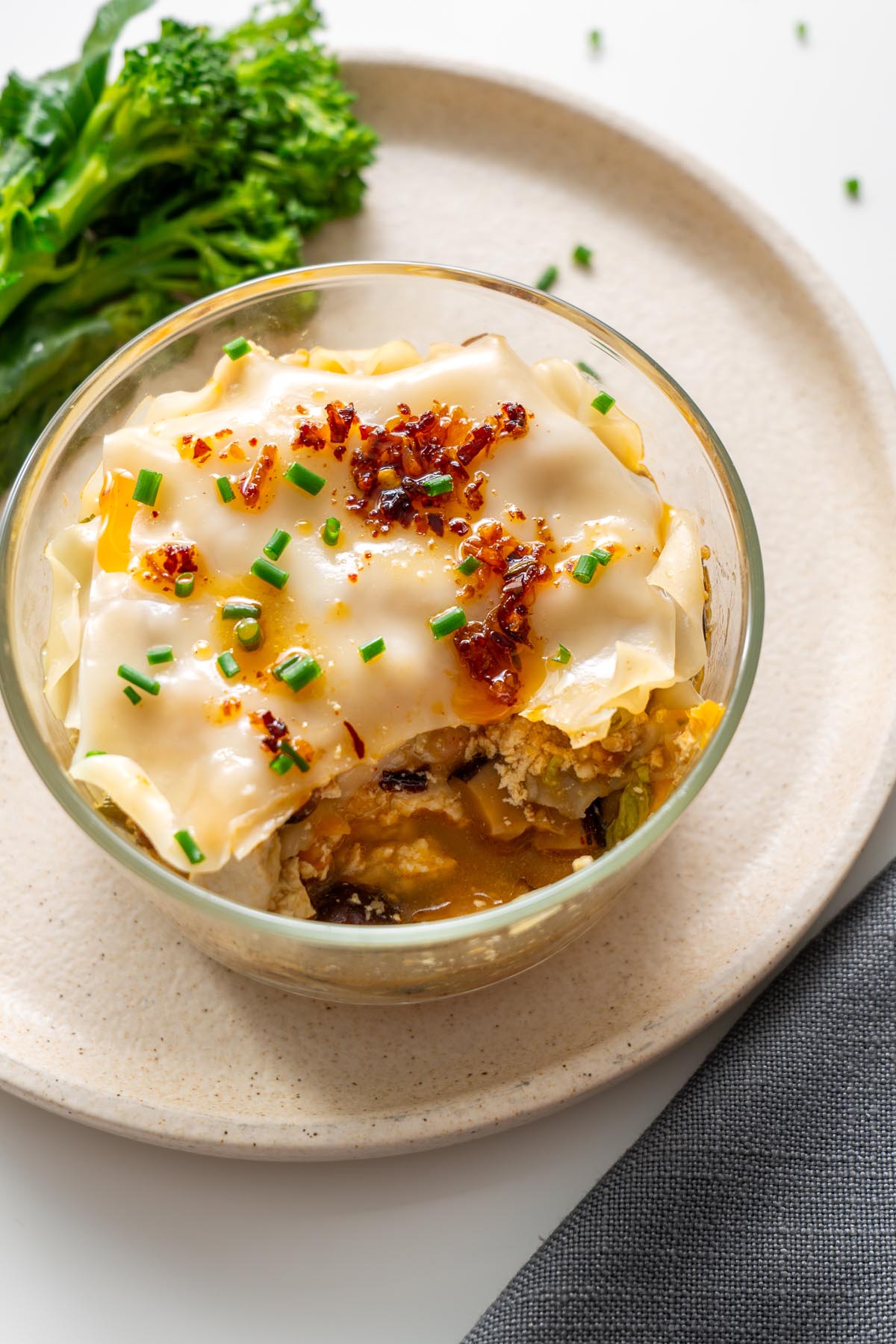 Soup dumpling lasagna in a glass bowl showing the savory filling inside.
