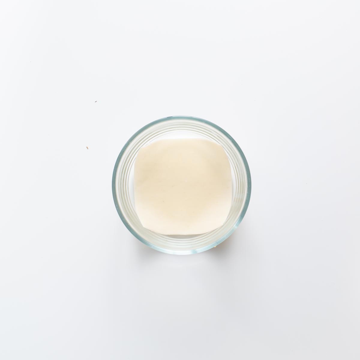 Step by step view of layering soup dumpling lasagna in a glass bowl.