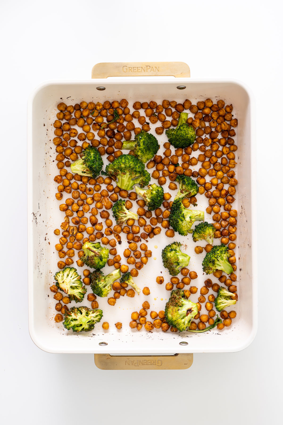 Roasted chickpeas and broccoli florets on a baking tray, baked until golden and crisp.