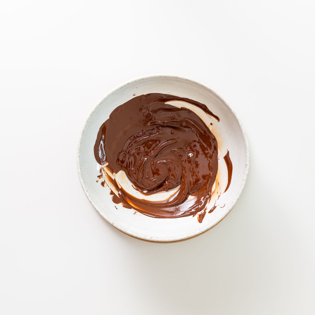 Melted dark chocolate in a bowl, swirled until smooth.