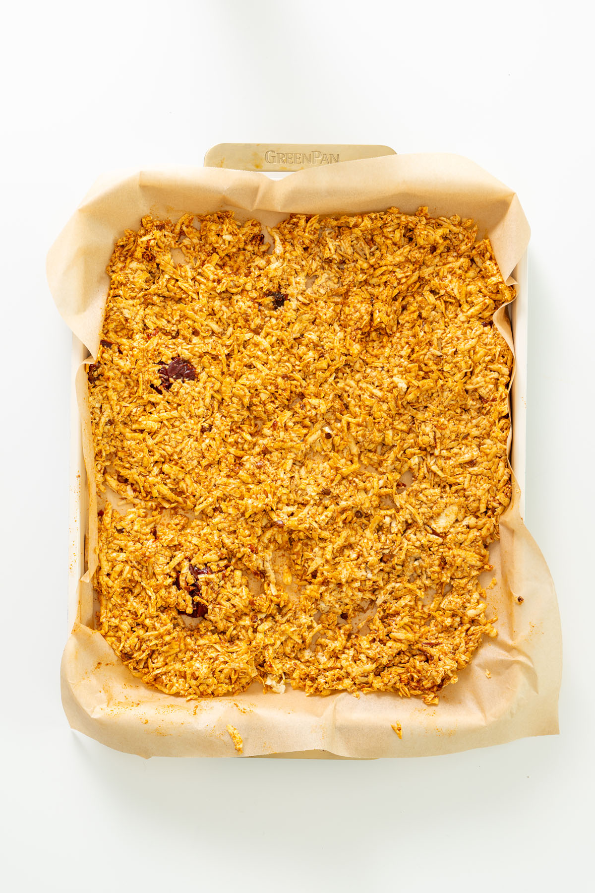 Grated tofu coated in chipotle seasoning spread on a parchment-lined baking tray before baking.