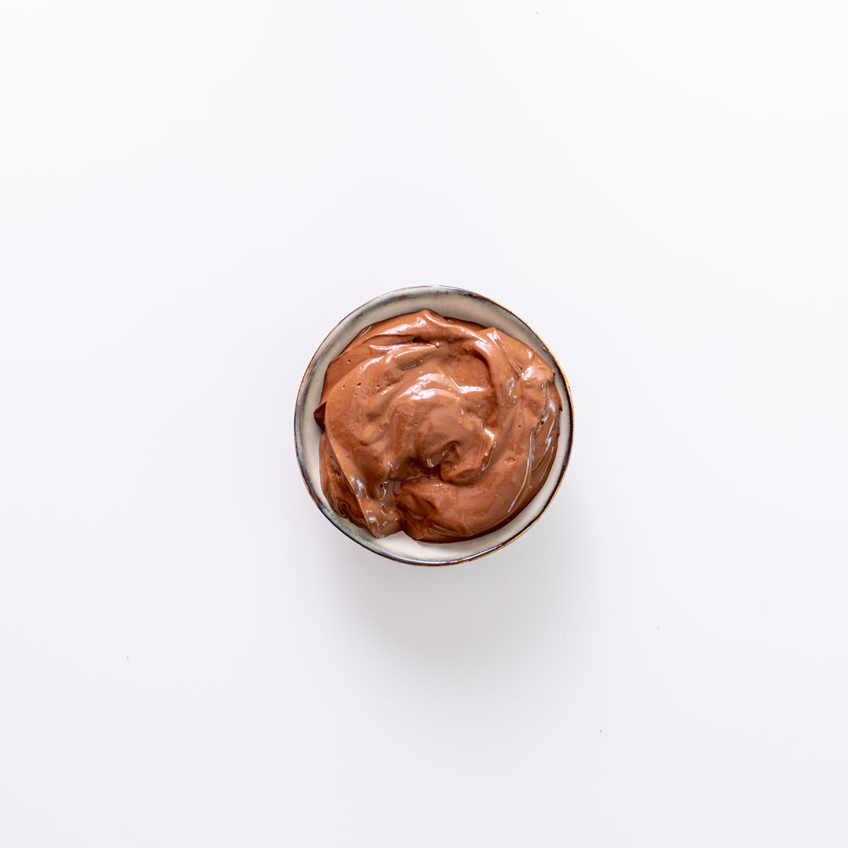 Chocolate mousse mixture in a small bowl on a white background.
