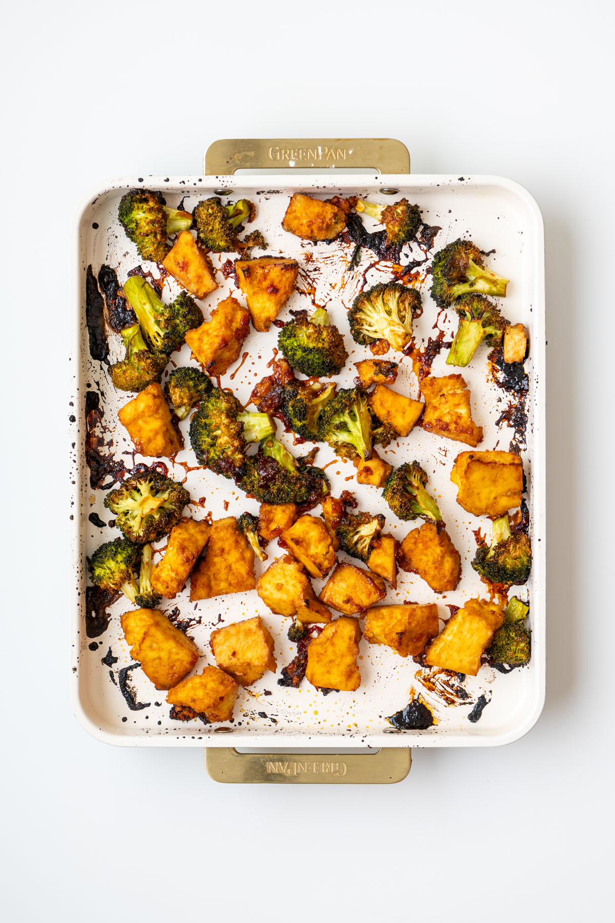 Golden roasted gochujang tofu and charred broccoli on a sheet pan fresh from the oven