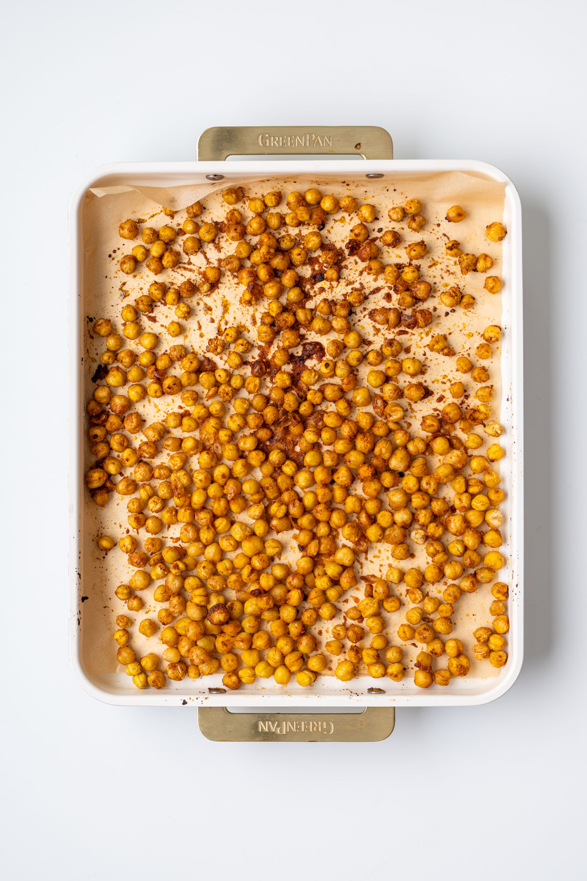 Crispy golden roasted chickpeas on a parchment-lined baking tray