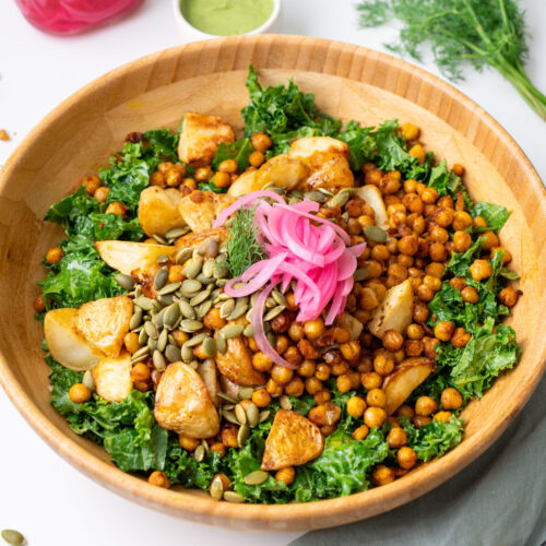 Roasted potato and avocado ranch salad in a wooden bowl with crispy chickpeas, kale, pumpkin seeds, and pickled red onion, styled with avocado ranch dressing and fresh dill