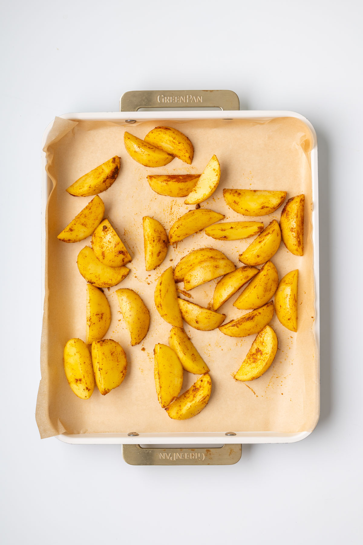 Golden roasted potatoes seasoned with smoked paprika, cumin, and turmeric on a parchment-lined baking tray