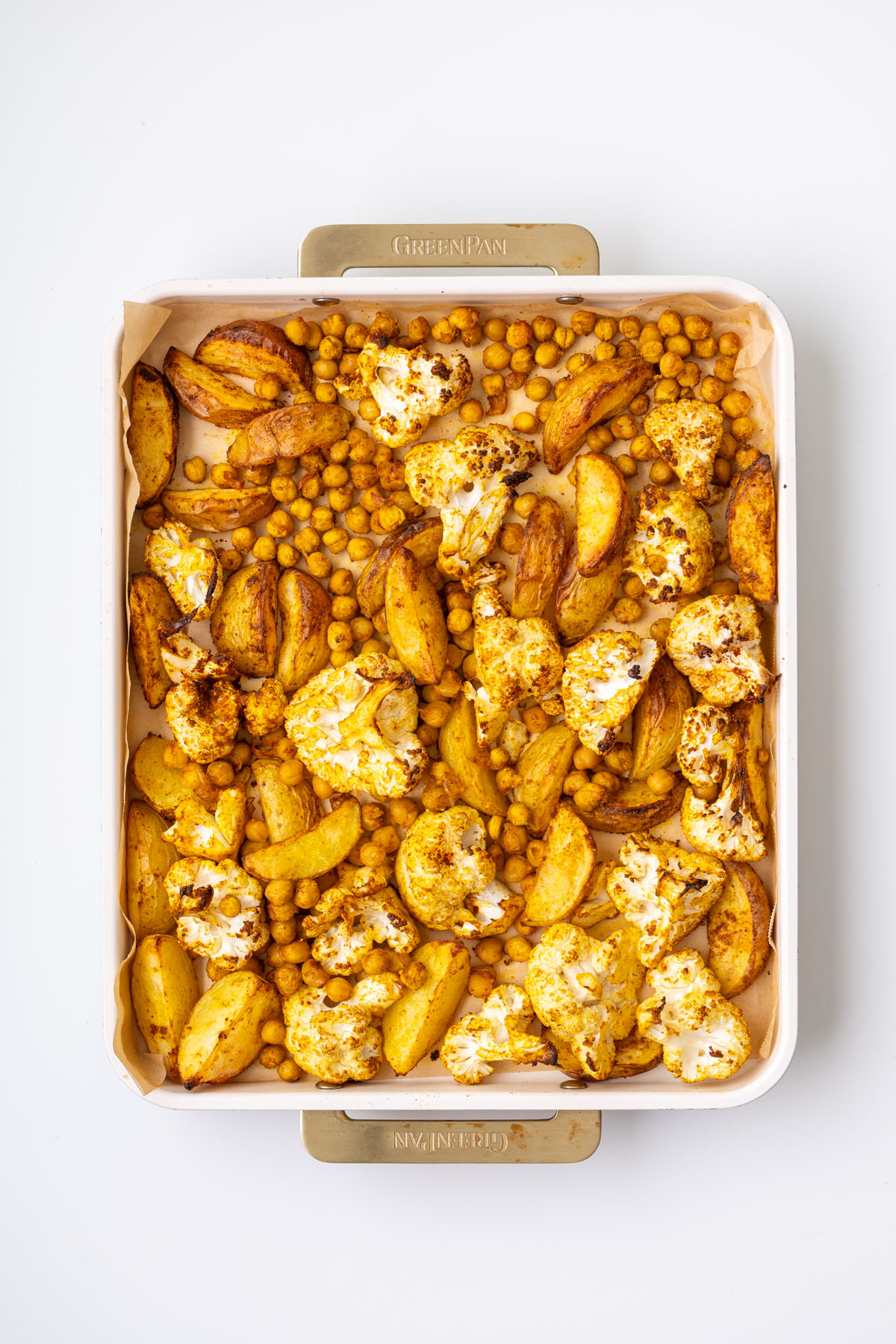 Roasted spiced potatoes and crispy chickpeas on a baking tray fresh from the oven