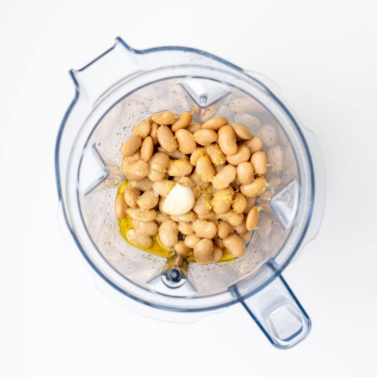 Butter beans, garlic, olive oil, and lemon zest in a blender before blending into a dip